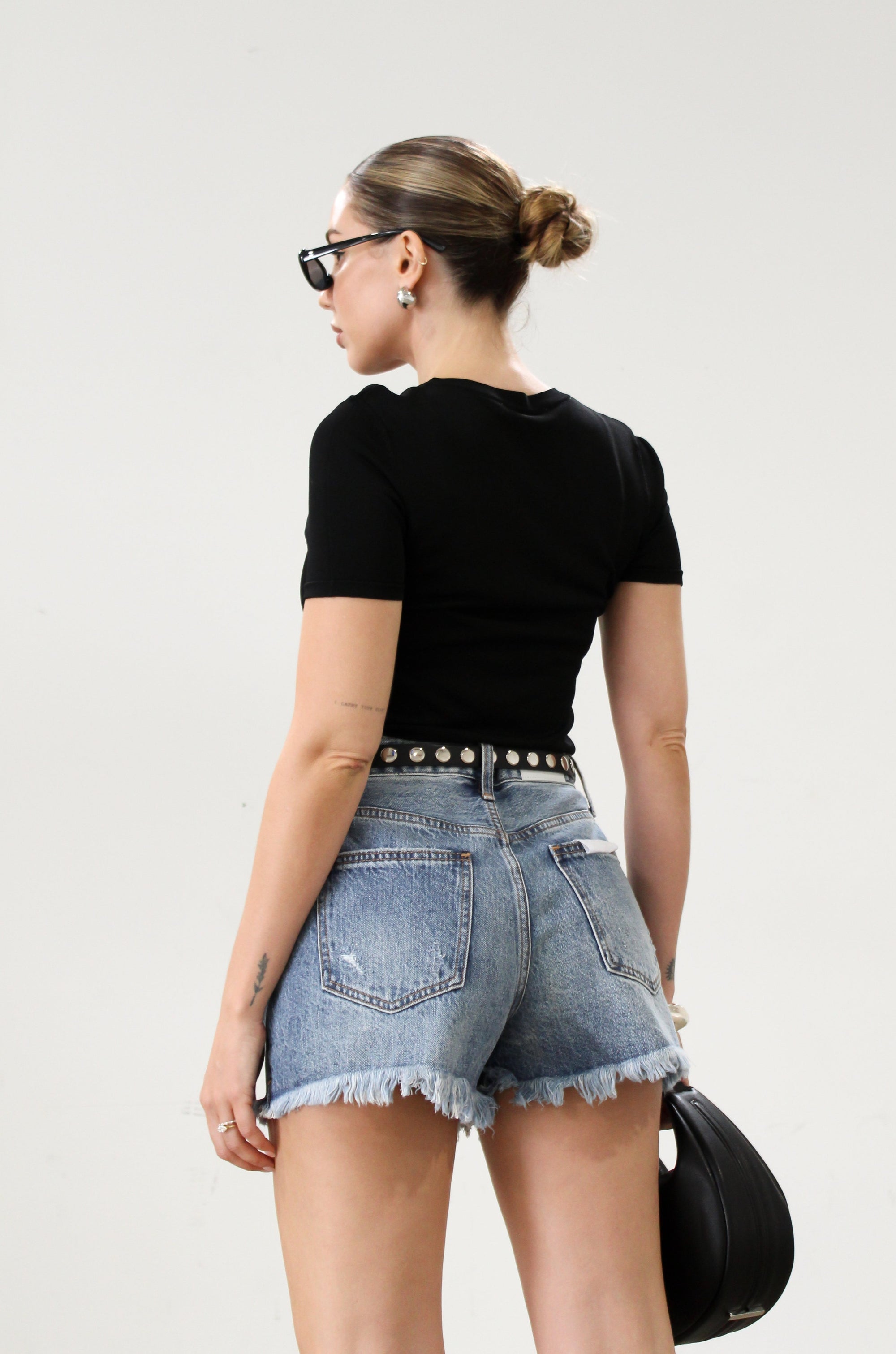 High-waisted faded and distressed denim shorts. Button and zipper fly closures. Five pocket construction. Frayed hem. True to size. Size up for a more relaxed look.