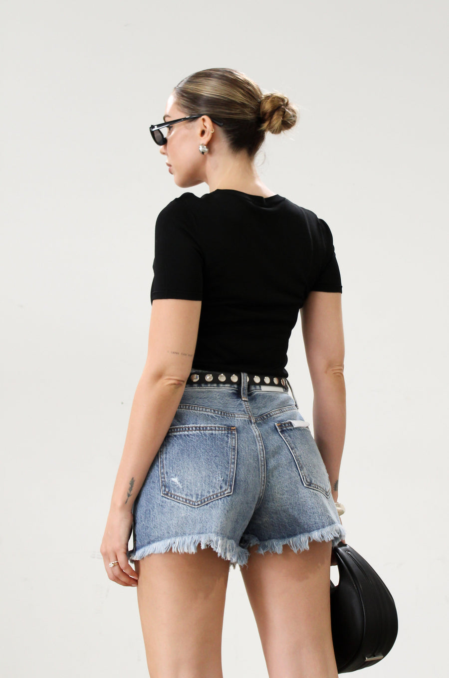 High-waisted faded and distressed denim shorts. Button and zipper fly closures. Five pocket construction. Frayed hem. True to size. Size up for a more relaxed look.