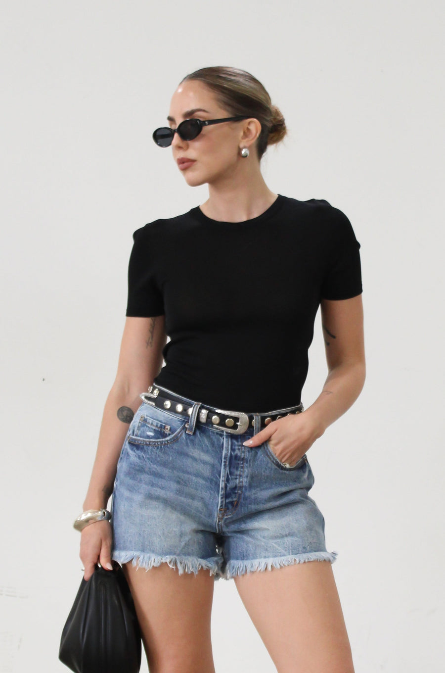 High-waisted faded and distressed denim shorts. Button and zipper fly closures. Five pocket construction. Frayed hem. True to size. Size up for a more relaxed look.