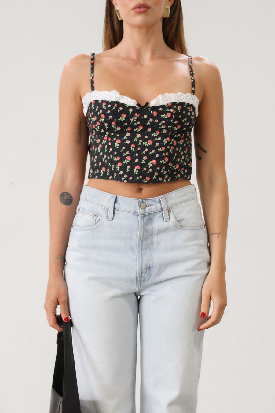 Floral printed woven cropped tank top. Adjustable straps. Boning in bodice. Elastic back strap with hook and eye closures. Back zipper closure. Fully lined.