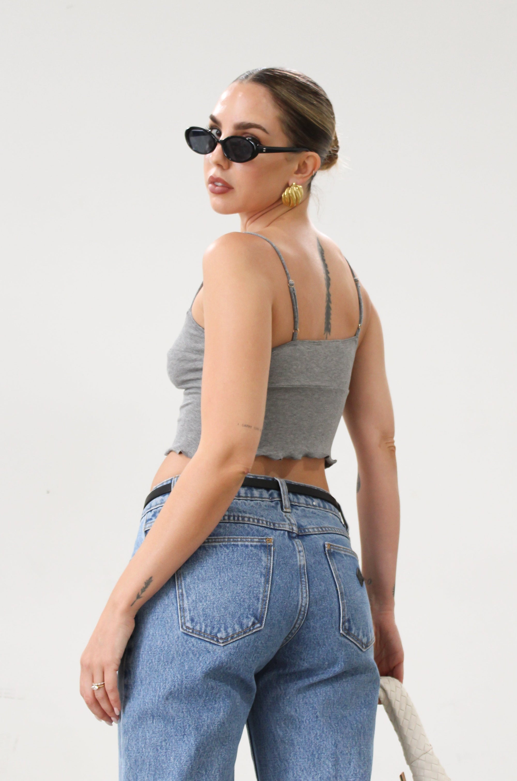 Ribbed knit cropped tank top. Adjustable straps. Lettuce edge hem. Unlined. basic crop top. basic tank top. basic grey tank top. grey tank top. grey crop tank top. everyday tank top