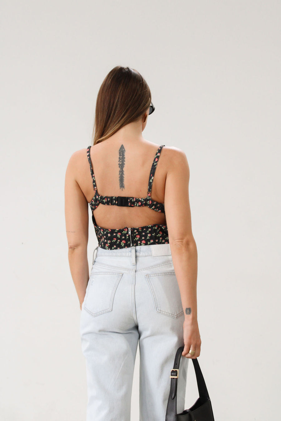 Floral printed woven cropped tank top. Adjustable straps. Boning in bodice. Elastic back strap with hook and eye closures. Back zipper closure. Fully lined.