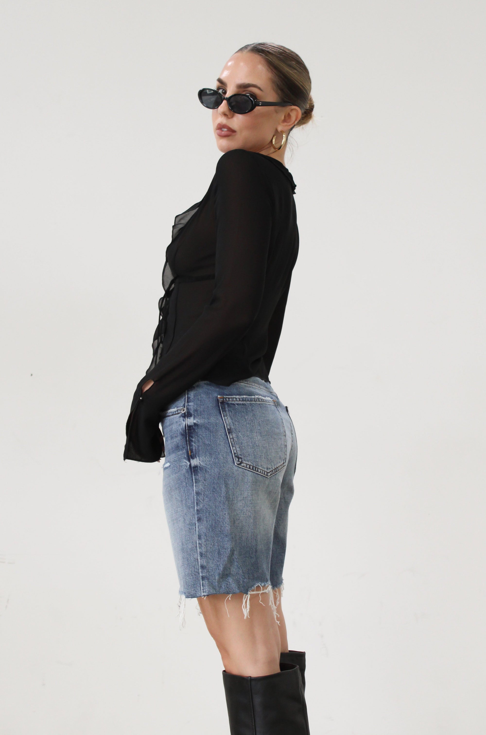 Faded and distressed denim bermuda shorts. Button and zipper fly. Five pocket construction. Frayed hem. Minimal stretch.