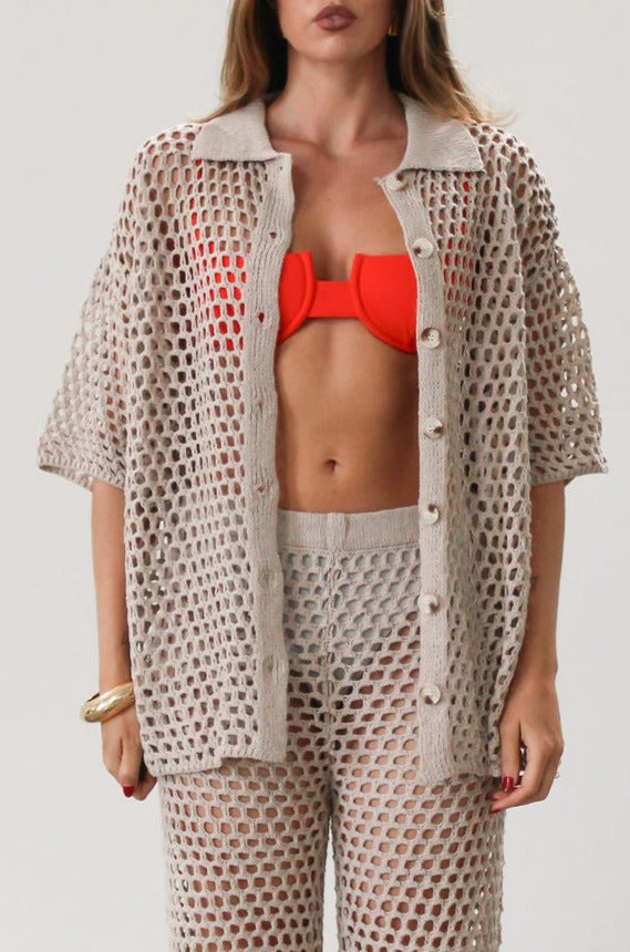 Open knit crochet shirt. Collar neckline. Short sleeves. Front button down closures. Unlined/sheer. Beach coverup. Pool coverup. Tan oat top
