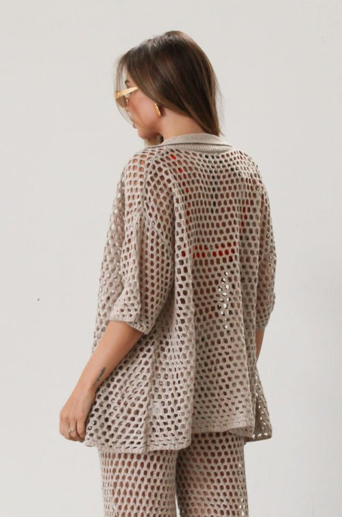 Open knit crochet shirt. Collar neckline. Short sleeves. Front button down closures. Unlined/sheer. Beach coverup. Pool coverup. Tan oat top