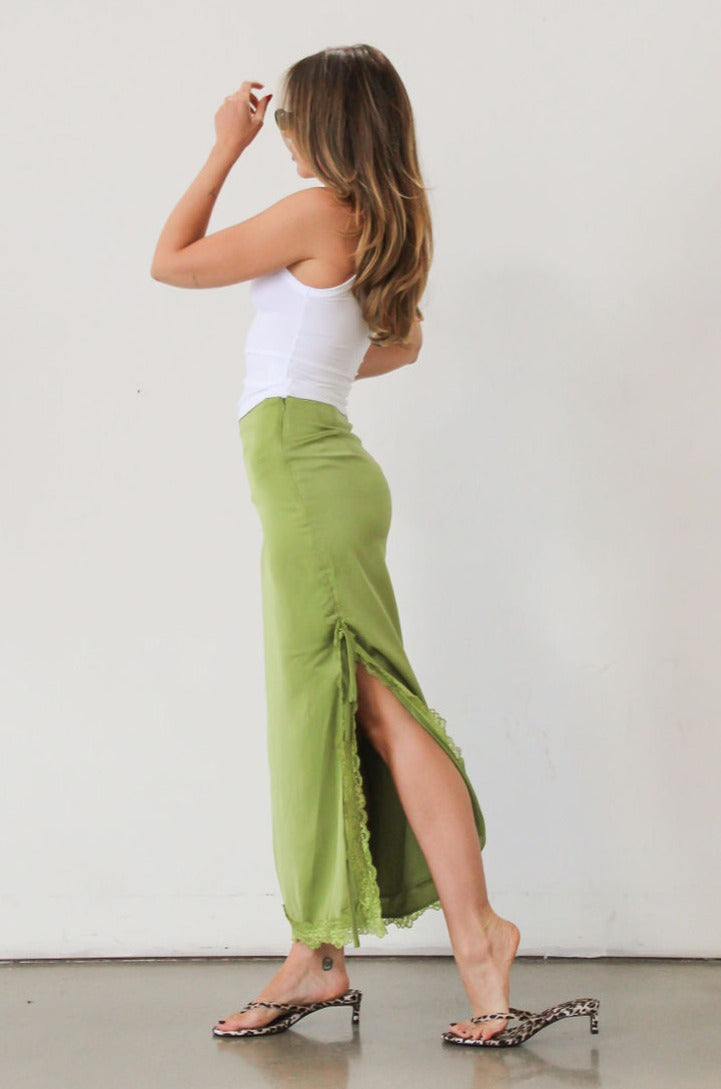 Satin maxi skirt. Side hook and eye and zipper closures. Side slits. Tie details. Lace trim. Fully lined. Green skirt.