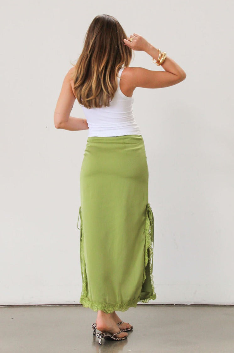 Satin maxi skirt. Side hook and eye and zipper closures. Side slits. Tie details. Lace trim. Fully lined. Green skirt.