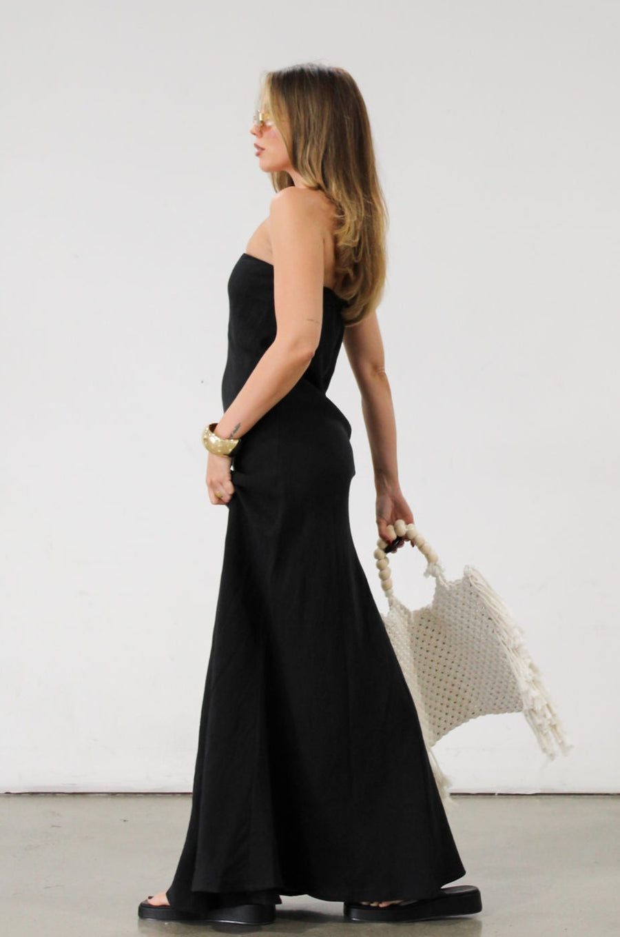 Linen woven maxi dress. Strapless neckline. Elastic back. Back zipper closure. Unlined. Black maxi dress. Black tie dress. Wedding guest dress.