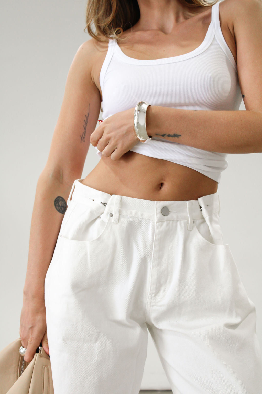 Wide leg jeans. Adjustable button waist closures. Button and zipper fly. Four pocket construction. Unlined. White jeans. White baggy jeans