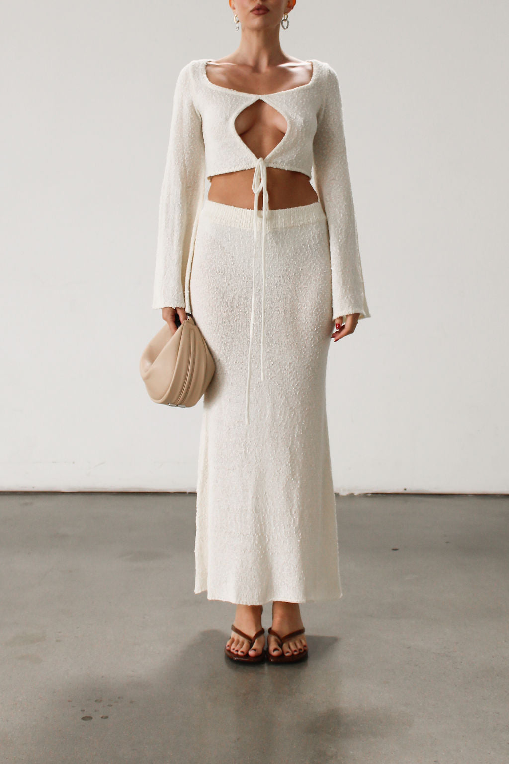 Cream maxi skirt set with long sleeve crop top.TOP: Textured crochet knit crop top. Long bell sleeves. Front keyhole and tie closure. Unlined  BOTTOM: Textured crochet knit maxi skirt. Elastic waist. Unlined.