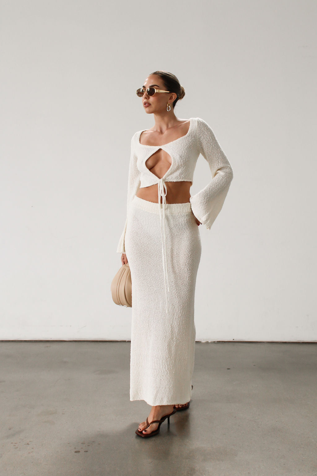 Cream maxi skirt set with long sleeve crop top.TOP: Textured crochet knit crop top. Long bell sleeves. Front keyhole and tie closure. Unlined  BOTTOM: Textured crochet knit maxi skirt. Elastic waist. Unlined.