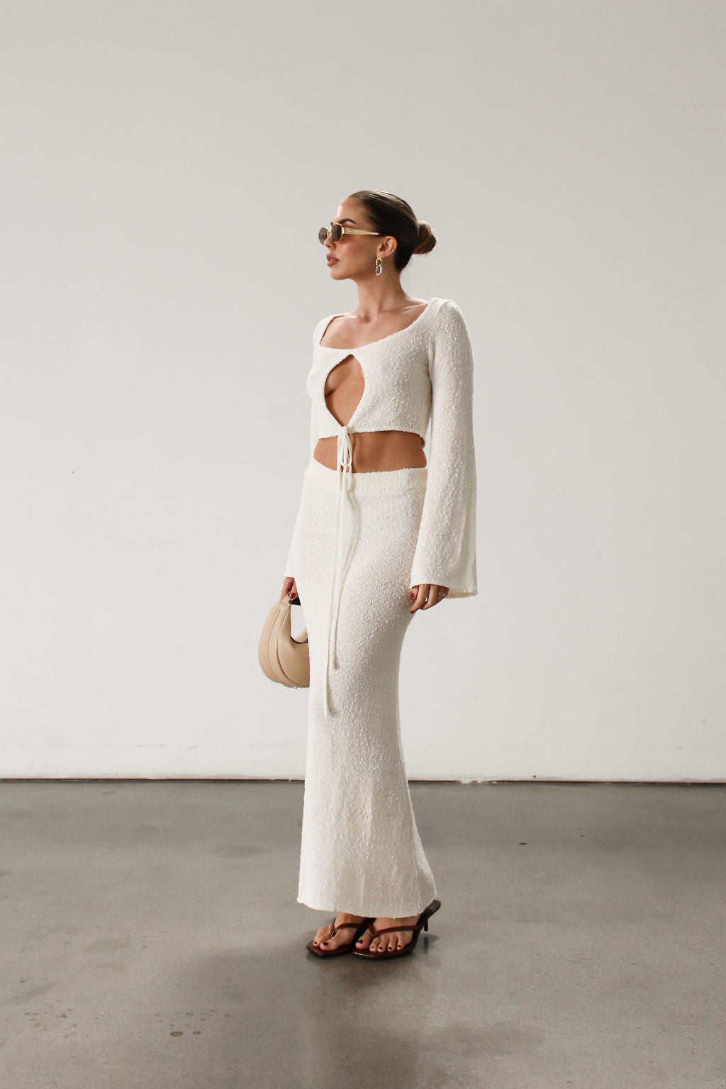 Cream maxi skirt set with long sleeve crop top.TOP: Textured crochet knit crop top. Long bell sleeves. Front keyhole and tie closure. Unlined  BOTTOM: Textured crochet knit maxi skirt. Elastic waist. Unlined.