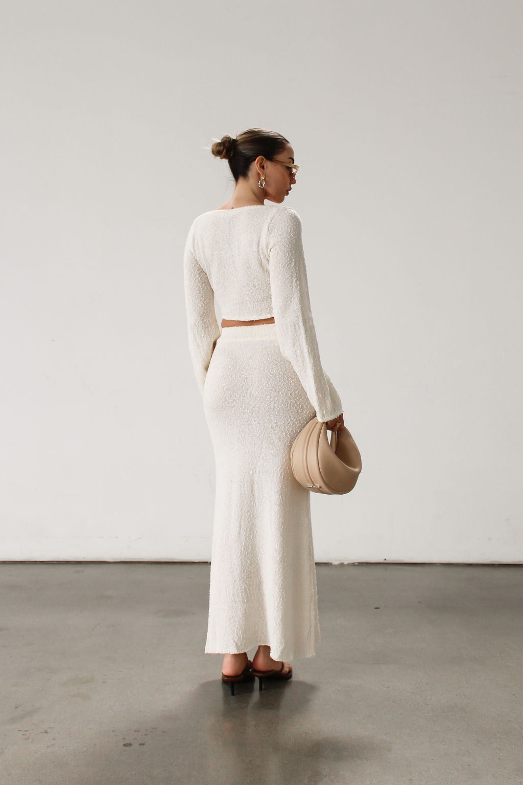 Cream maxi skirt set with long sleeve crop top.TOP: Textured crochet knit crop top. Long bell sleeves. Front keyhole and tie closure. Unlined  BOTTOM: Textured crochet knit maxi skirt. Elastic waist. Unlined.