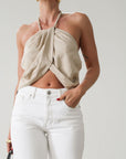 Woven crop top. Beaded halter neckline with adjustable tie closure. Front snap closure. Unlined. Tan/nude