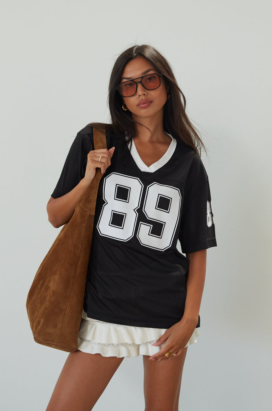 Mesh jersey t-shirt. V-neckline. Short sleeves. Side slits. Unlined/sheer. black jersey top. sporty casual outfit. summer top