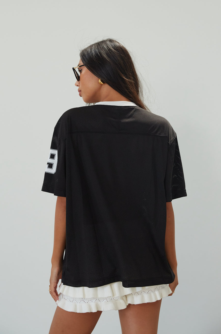 Mesh jersey t-shirt. V-neckline. Short sleeves. Side slits. Unlined/sheer. black jersey top. sporty casual outfit. summer top
