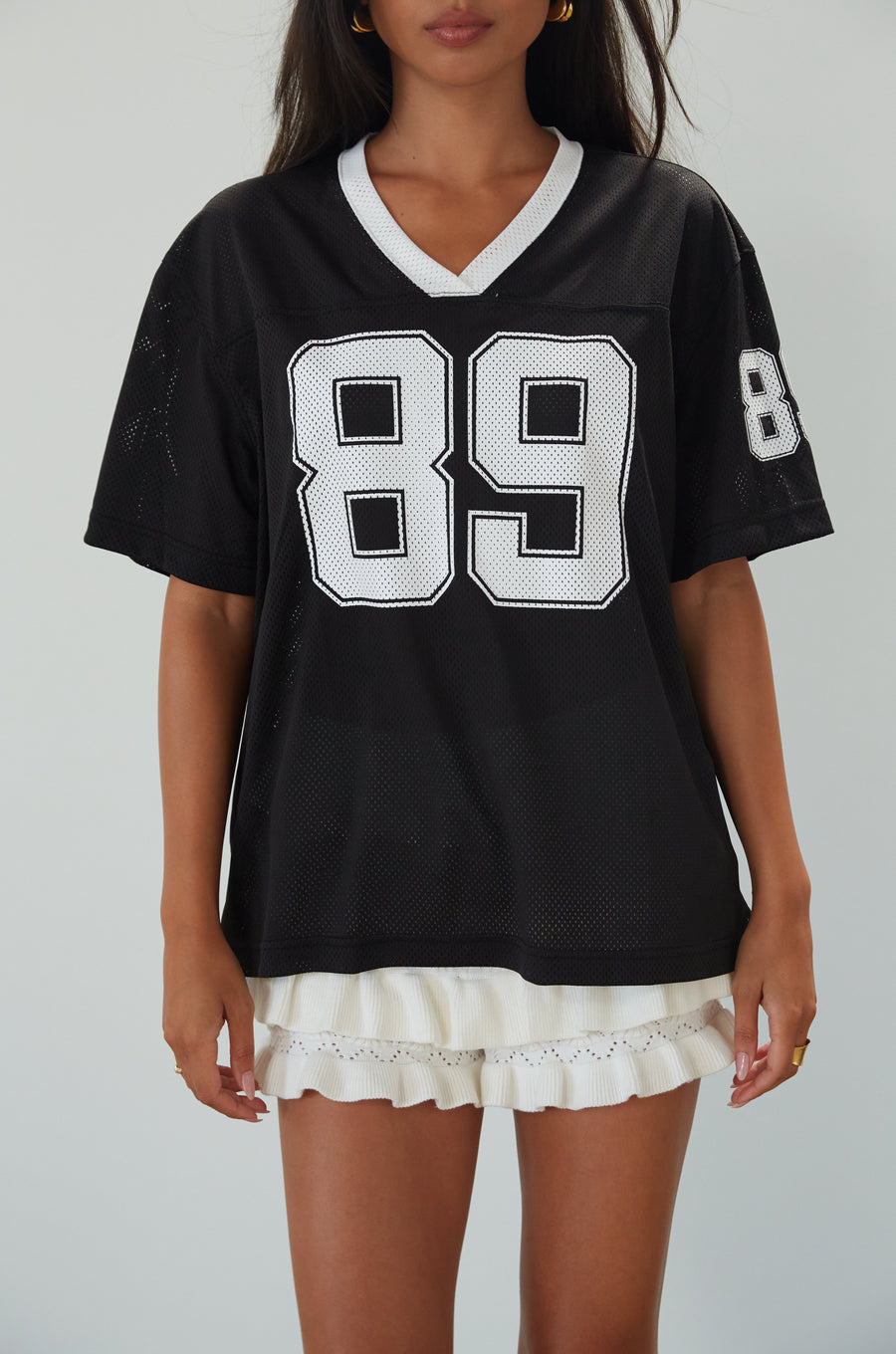 Mesh jersey t-shirt. V-neckline. Short sleeves. Side slits. Unlined/sheer. black jersey top. sporty casual outfit. summer top