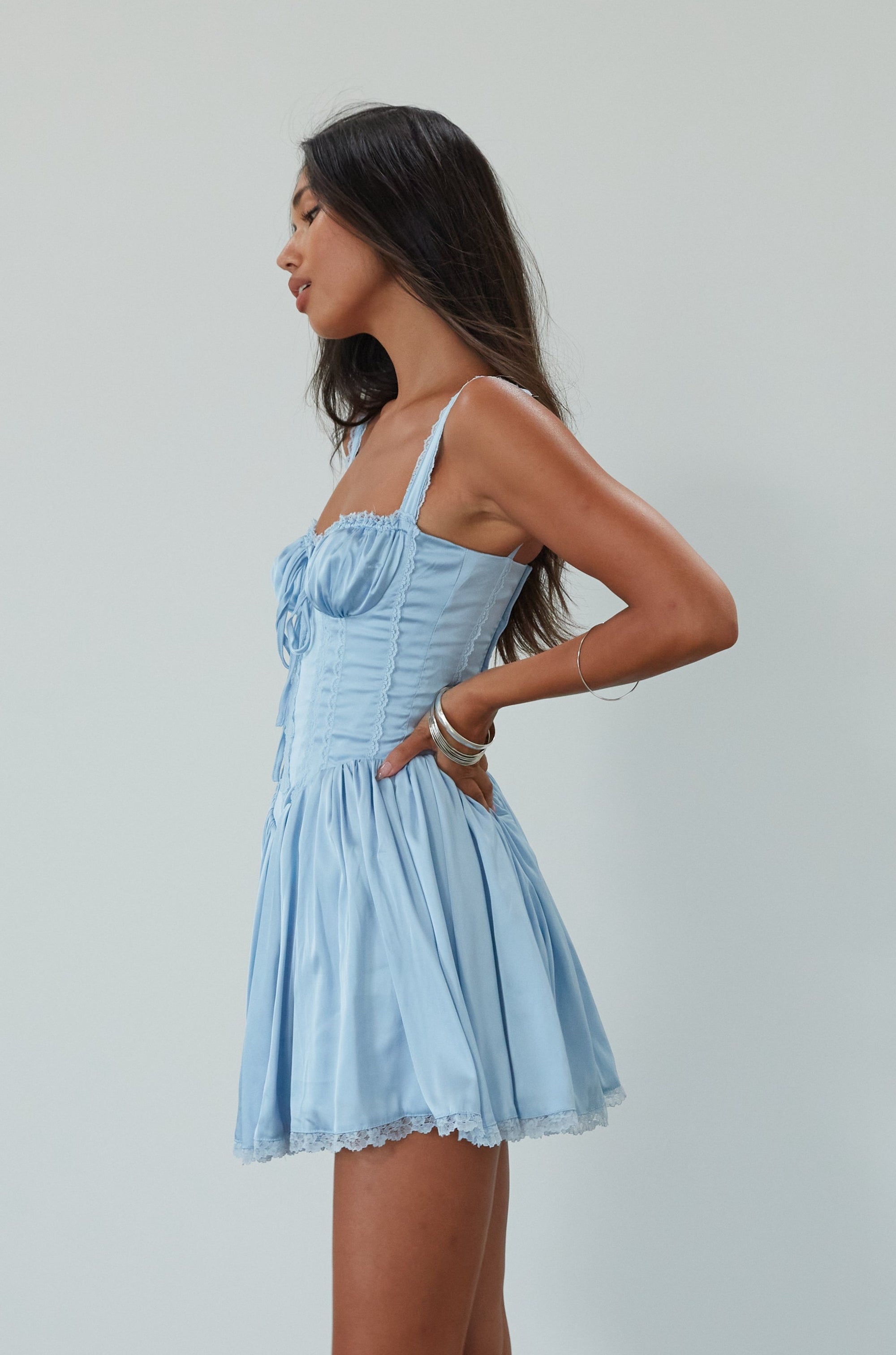 Satin dress with lace trim. Adjustable straps. Front tie closure. Underwire cups. Boning in bodice. Back lace up closure. Elastic back waist. Fully lined. blue satin mini dress. summer dress. fancy mini dress.