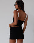 Black Knit mini skirt. Side&nbsp;hook and eye and zipper closures. Raw edge hem. Unlined.