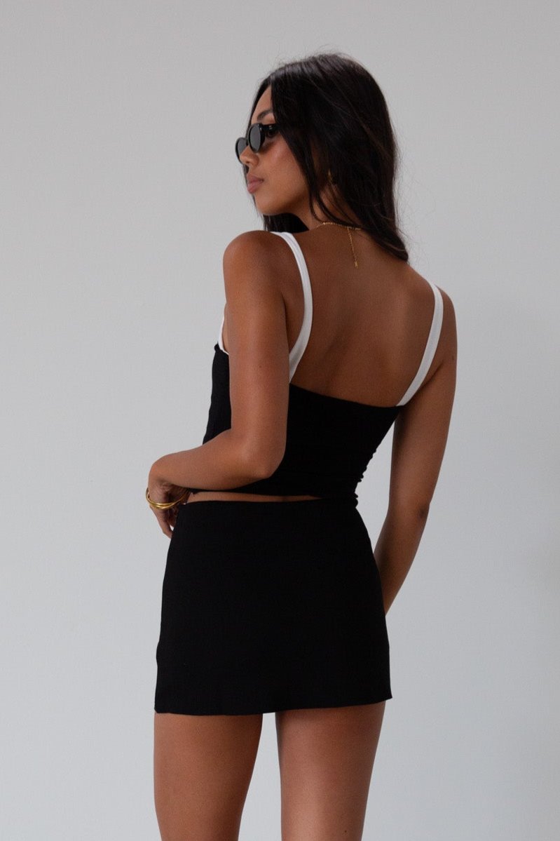 Black Knit mini skirt. Side&nbsp;hook and eye and zipper closures. Raw edge hem. Unlined.