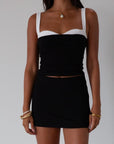 Black Knit mini skirt. Side&nbsp;hook and eye and zipper closures. Raw edge hem. Unlined.