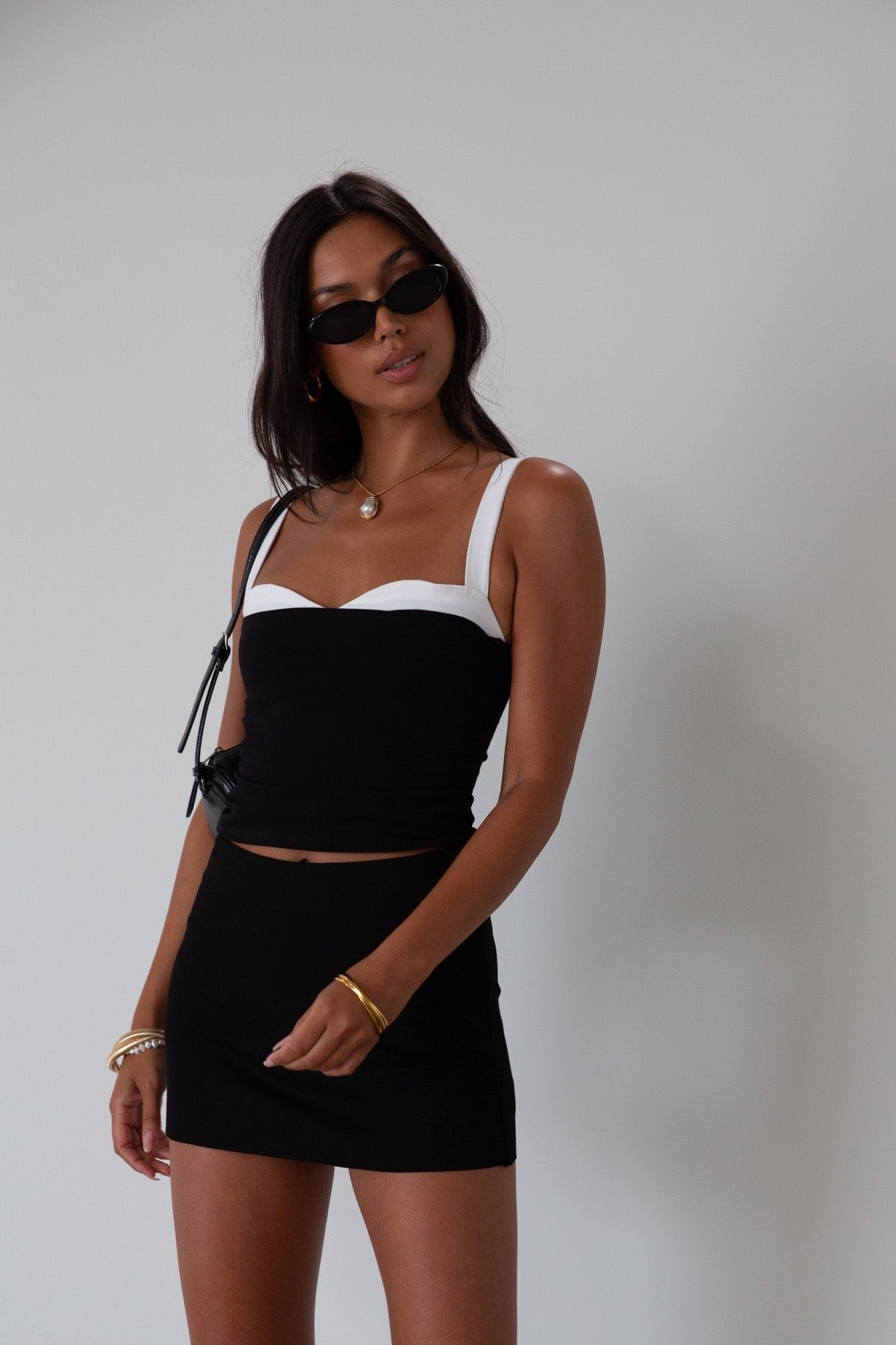 Black Knit mini skirt. Side&nbsp;hook and eye and zipper closures. Raw edge hem. Unlined.