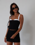 Black Knit mini skirt. Side&nbsp;hook and eye and zipper closures. Raw edge hem. Unlined.