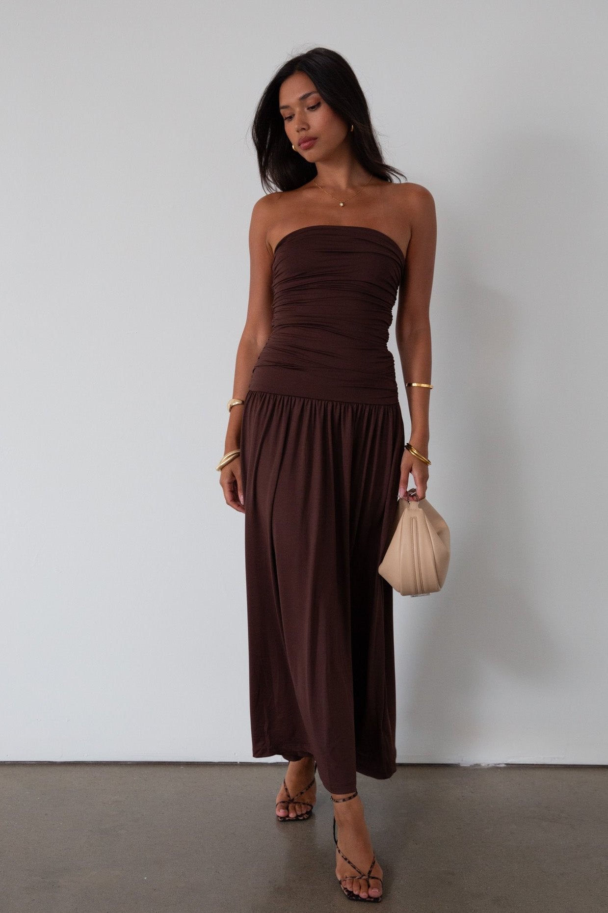 Knit maxi dress. Strapless elastic neckline. Inner rubber grip lining. Ruched slides. Partially lined. brown maxi dress. brown starpless maxi dress. summer dress. wedding guest dress