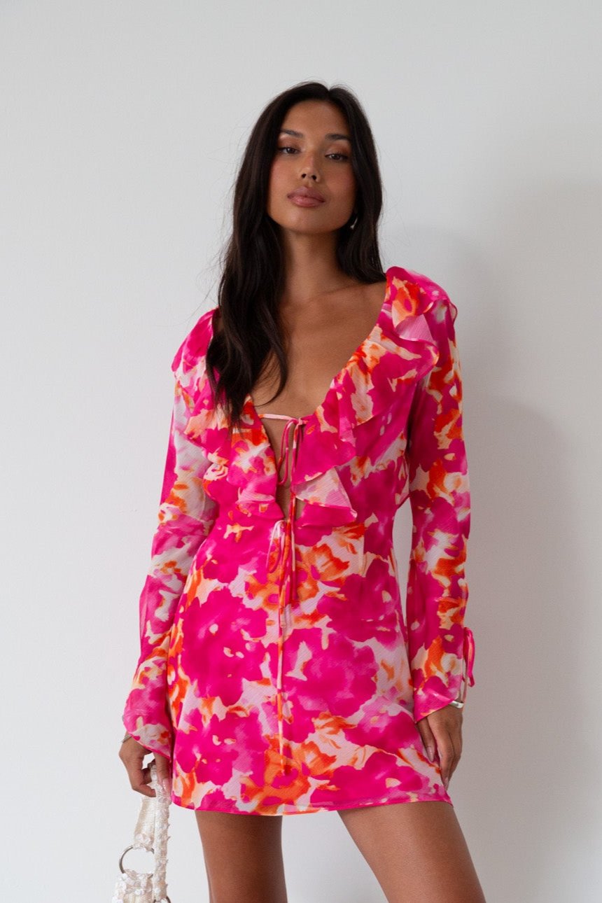 Printed chiffon dress. Long sleeves with tie closure. Front and back tie closures. Ruffle deep v-neckline. Side zipper closure. Fully lined. floral mini dress. pink floral mini dress