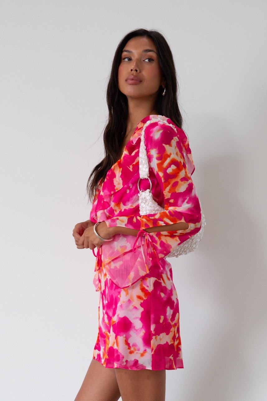 Printed chiffon dress. Long sleeves with tie closure. Front and back tie closures. Ruffle deep v-neckline. Side zipper closure. Fully lined. floral mini dress. pink floral mini dress