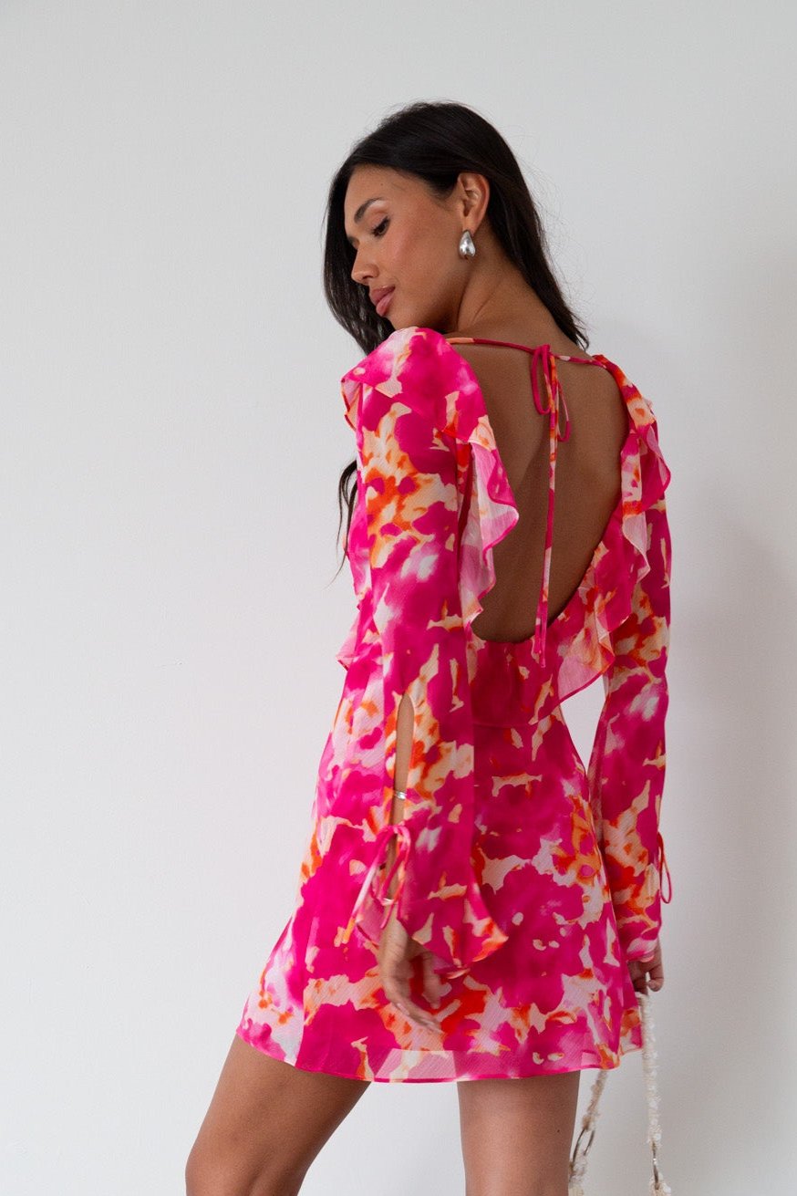 Printed chiffon dress. Long sleeves with tie closure. Front and back tie closures. Ruffle deep v-neckline. Side zipper closure. Fully lined. floral mini dress. pink floral mini dress