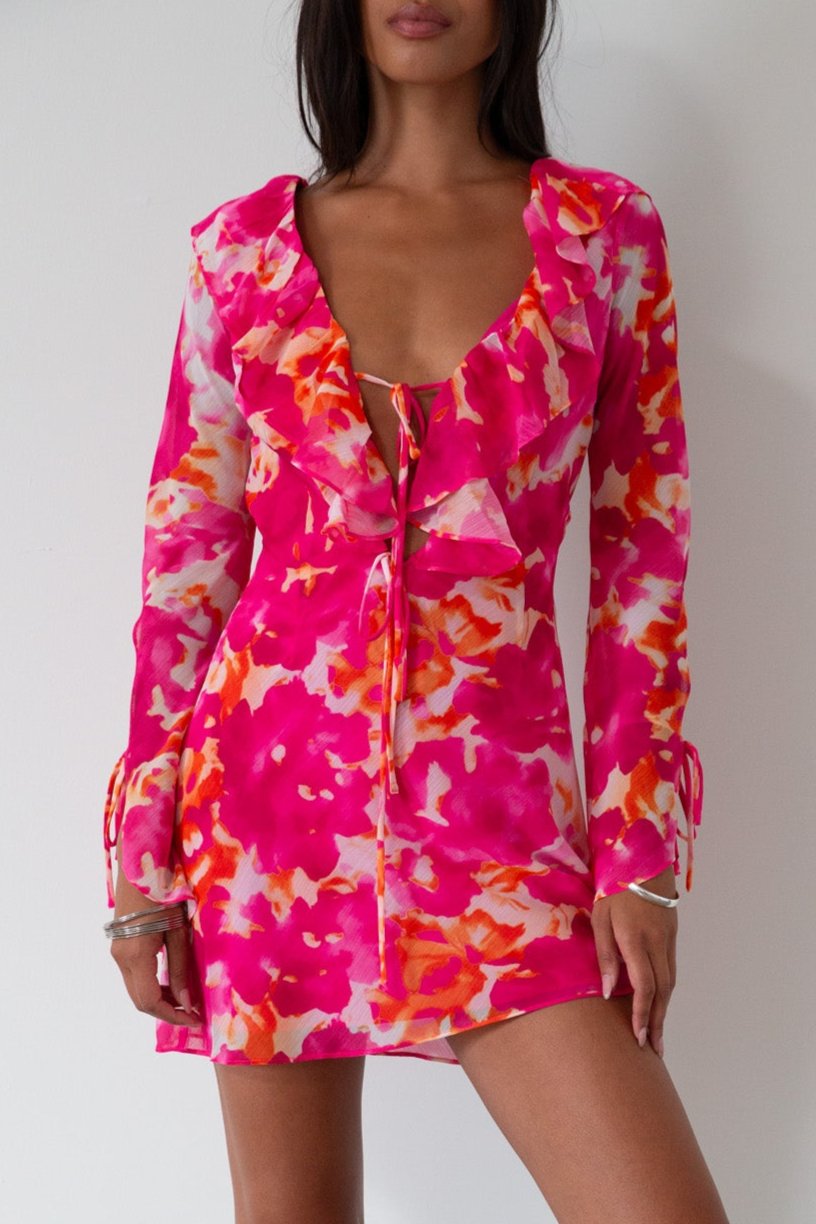 Printed chiffon dress. Long sleeves with tie closure. Front and back tie closures. Ruffle deep v-neckline. Side zipper closure. Fully lined. floral mini dress. pink floral mini dress