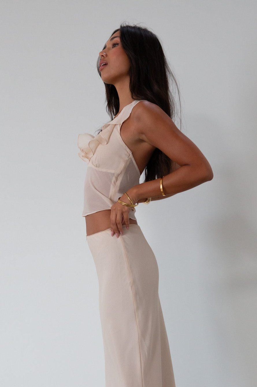 Chiffon crop top. Halter neckline with back button closures. Ruffle trimmed deep v-neckline. Side hook and eye and zipper closures. Partially lined. ruffle top. ruffle tank top. nude top. coquette top