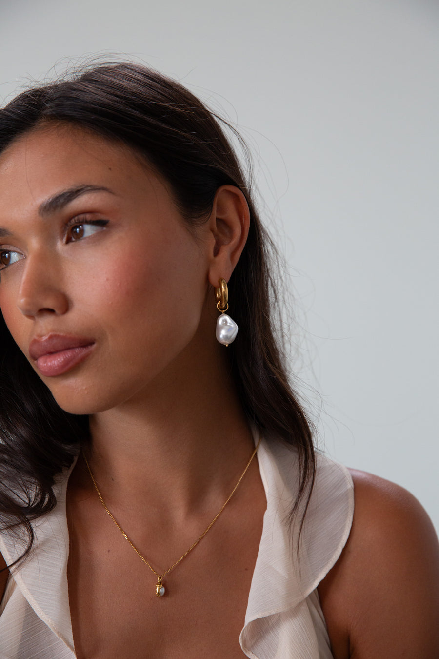 Small thick hoop earrings with pearl drop detail. Hinge closure.