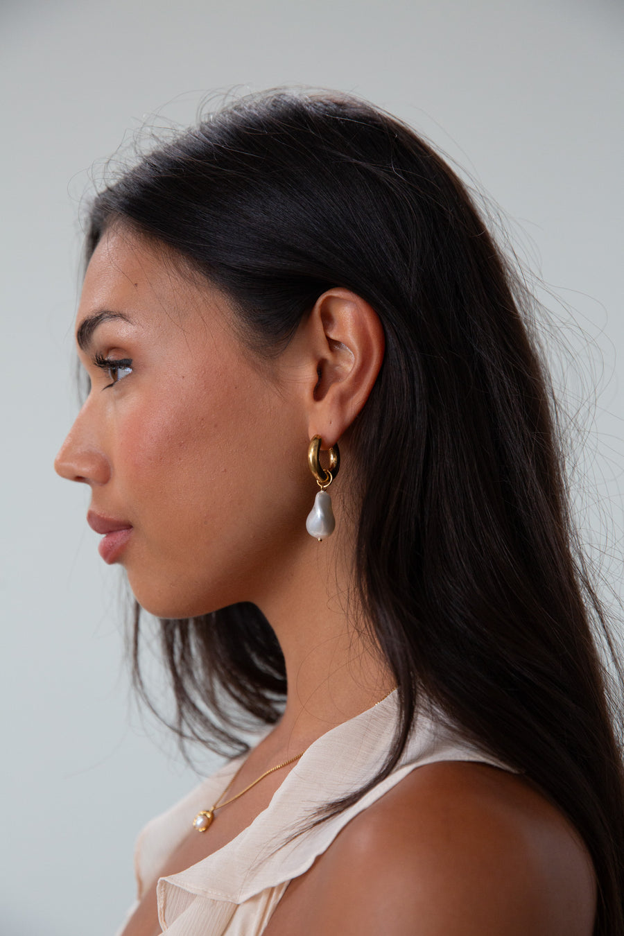 Small thick hoop earrings with pearl drop detail. Hinge closure.