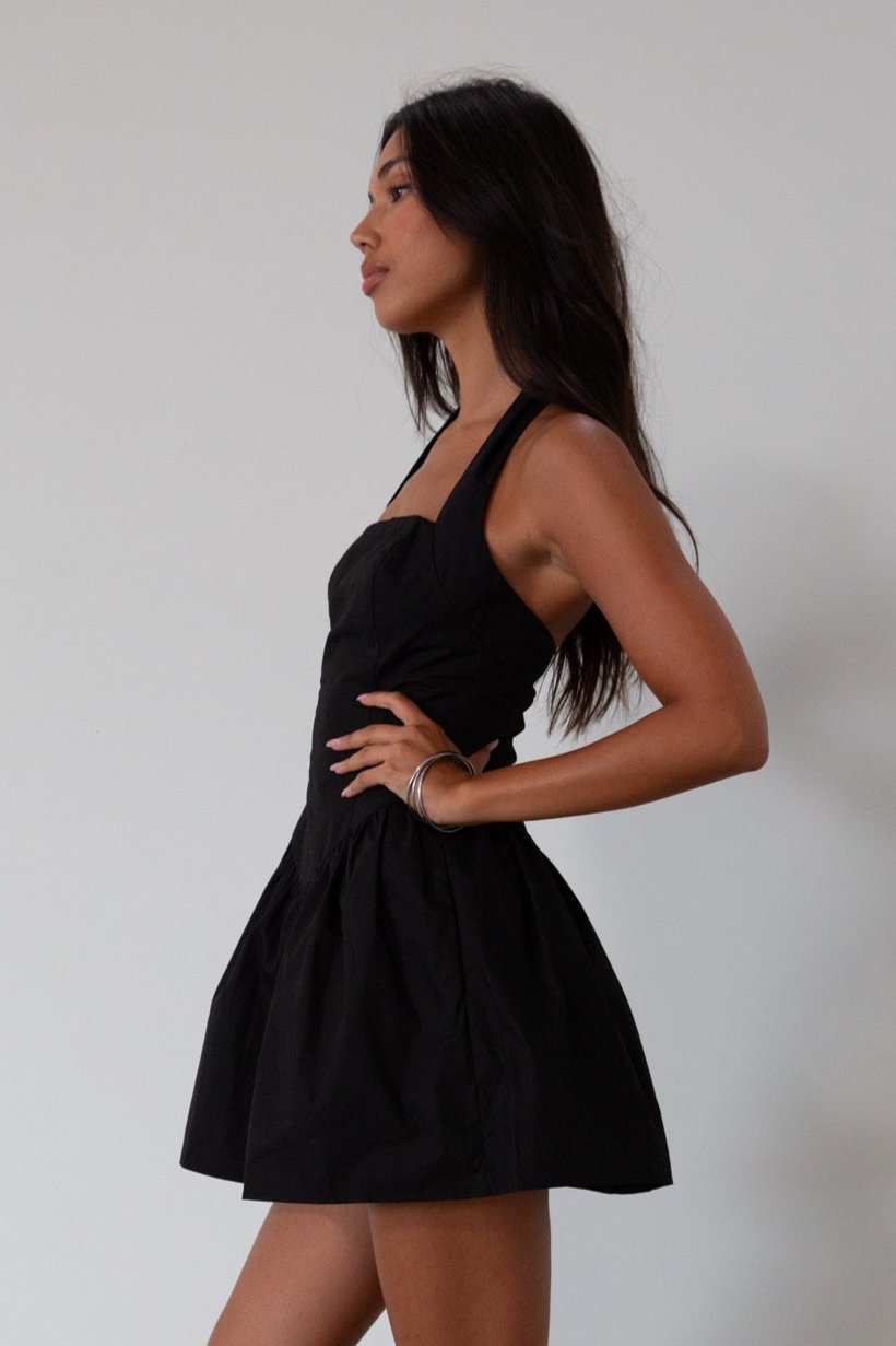 Woven dress. Halter neckline with button closures. Side pockets. Back hook and eye and zipper closures. Fully lined. black mini dress. black mini bubble dress. summer dress