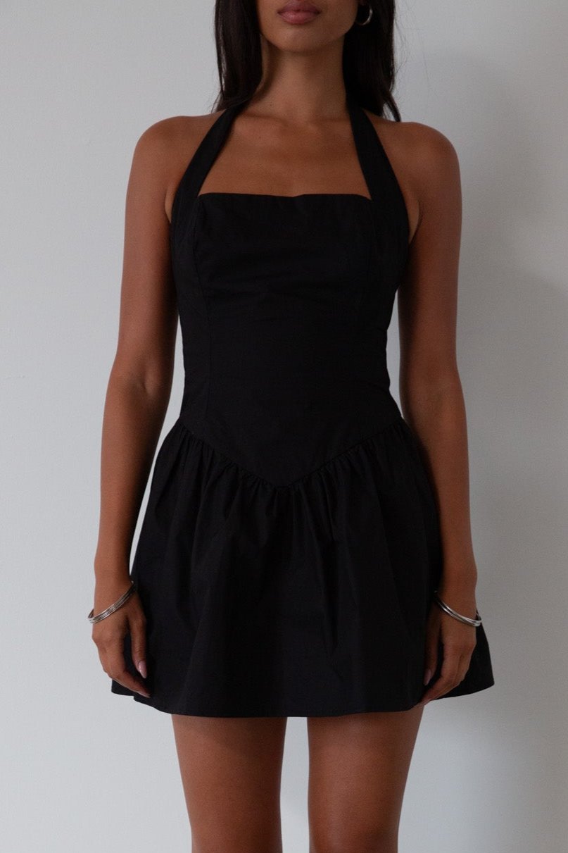 Woven dress. Halter neckline with button closures. Side pockets. Back hook and eye and zipper closures. Fully lined. black mini dress. black mini bubble dress. summer dress