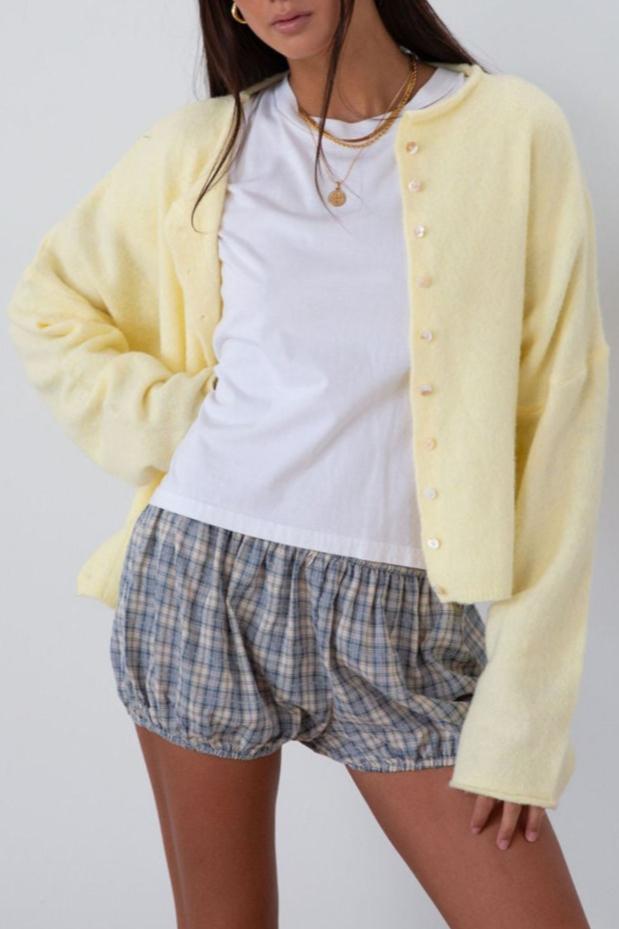 Fuzzy butter yellow knit cardigan. Crewneck. Front button down closures. Long sleeves. Unlined. fall transition outfit.
