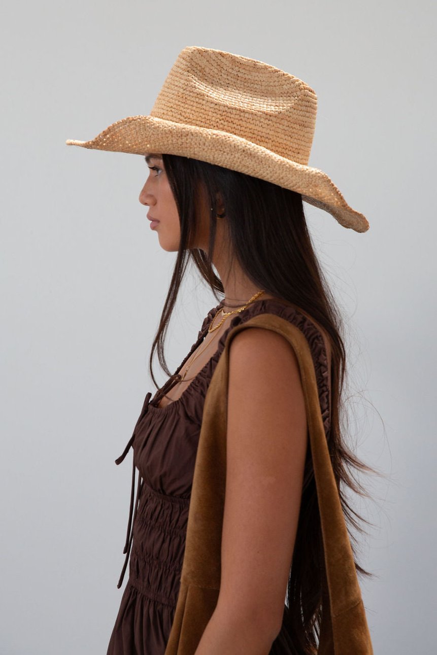 Straw cowboy hat. Pinched crown. Upturned brim.