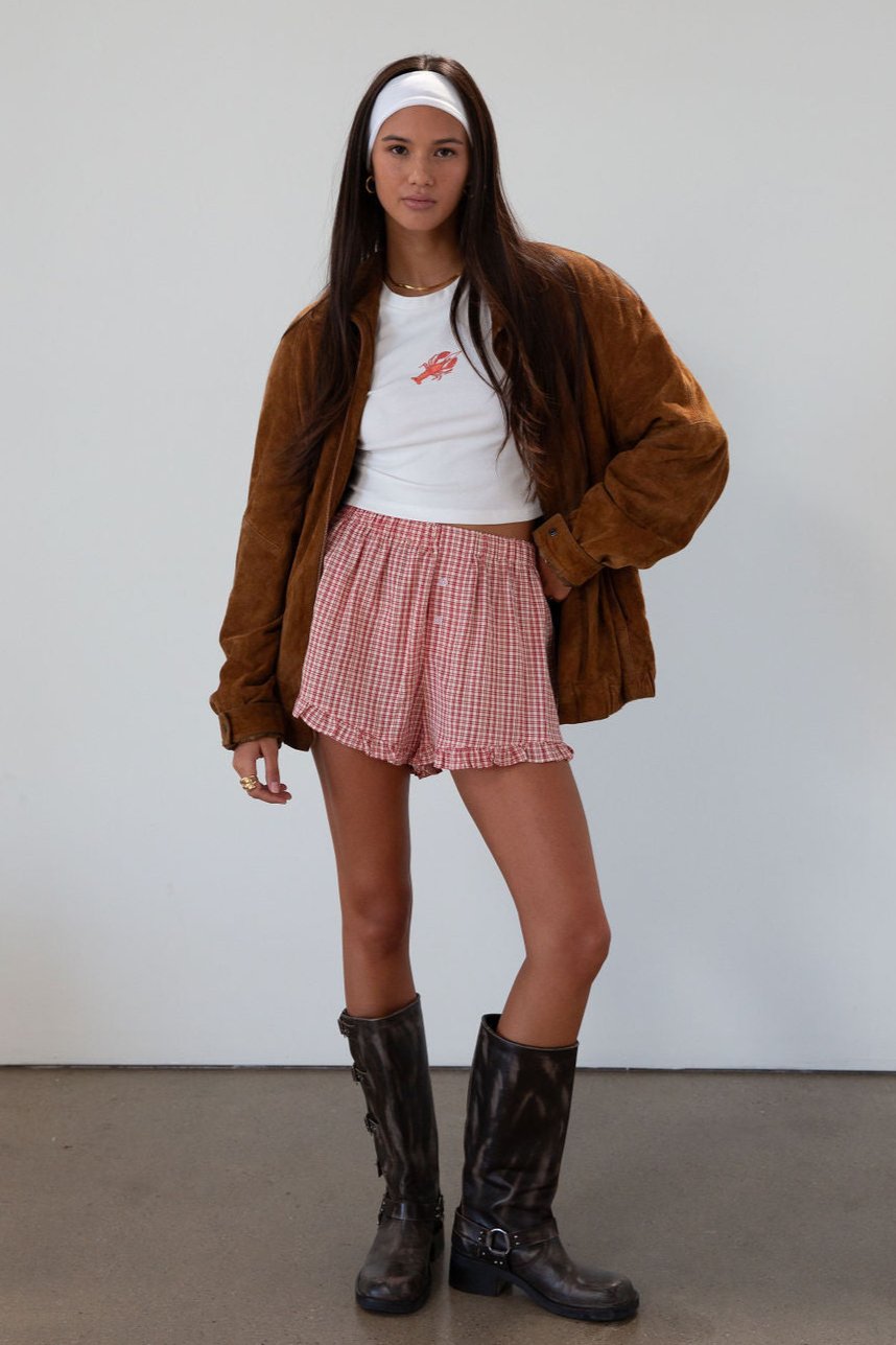 Checkered woven shorts. Elastic waist. Faux button fly. Ruffle trim hem. Unlined. red checkered shorts