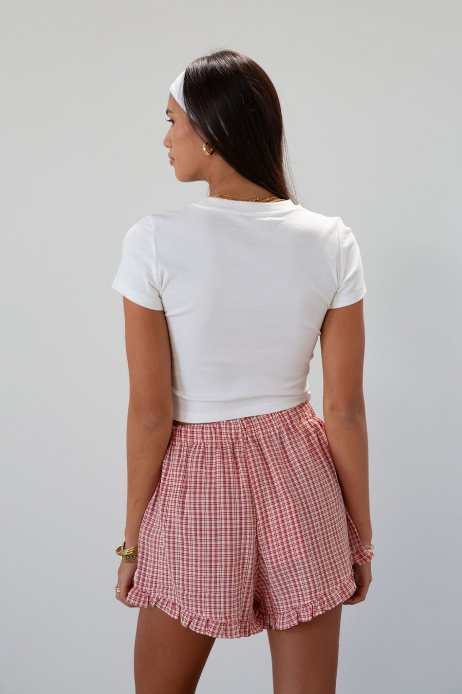 Checkered woven shorts. Elastic waist. Faux button fly. Ruffle trim hem. Unlined. red checkered shorts