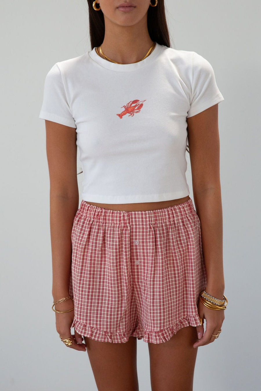 Checkered woven shorts. Elastic waist. Faux button fly. Ruffle trim hem. Unlined. red checkered shorts
