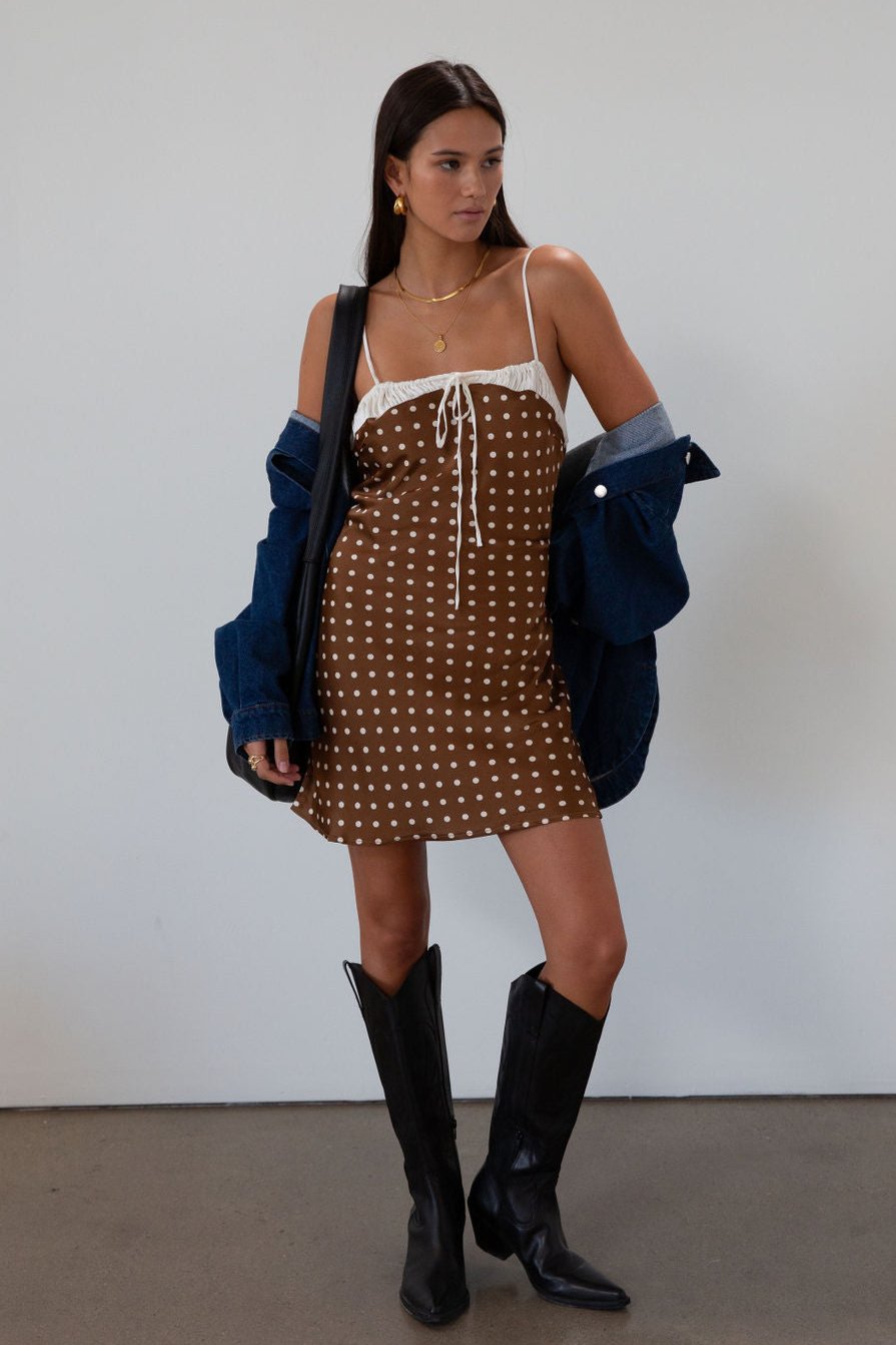 Polka dot printed satin dress. Adjustable straps. Front tie closure. Back hook and eye and zipper closures. Fully lined. brown mini dress. brown polka dot dress. fall outfit