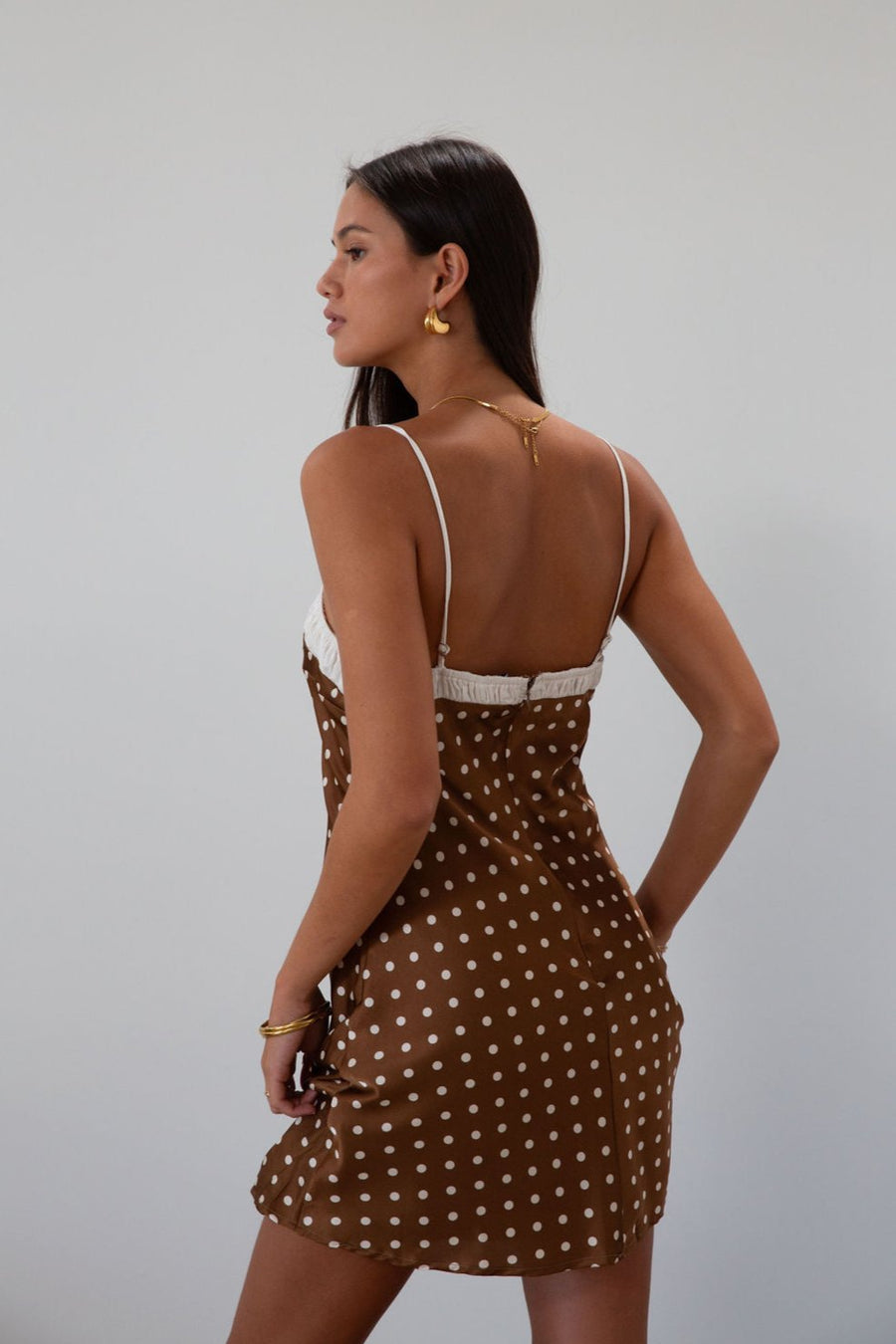Polka dot printed satin dress. Adjustable straps. Front tie closure. Back hook and eye and zipper closures. Fully lined. brown mini dress. brown polka dot dress. fall outfit
