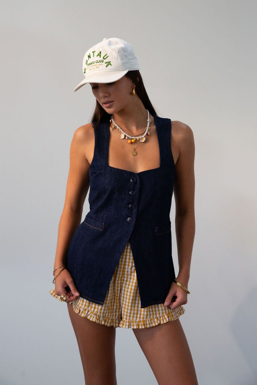 Denim sleeveless top. Fixed straps. Front button down closures. Faux front pockets. Adjustable back tie closure. Unlined. denim vest