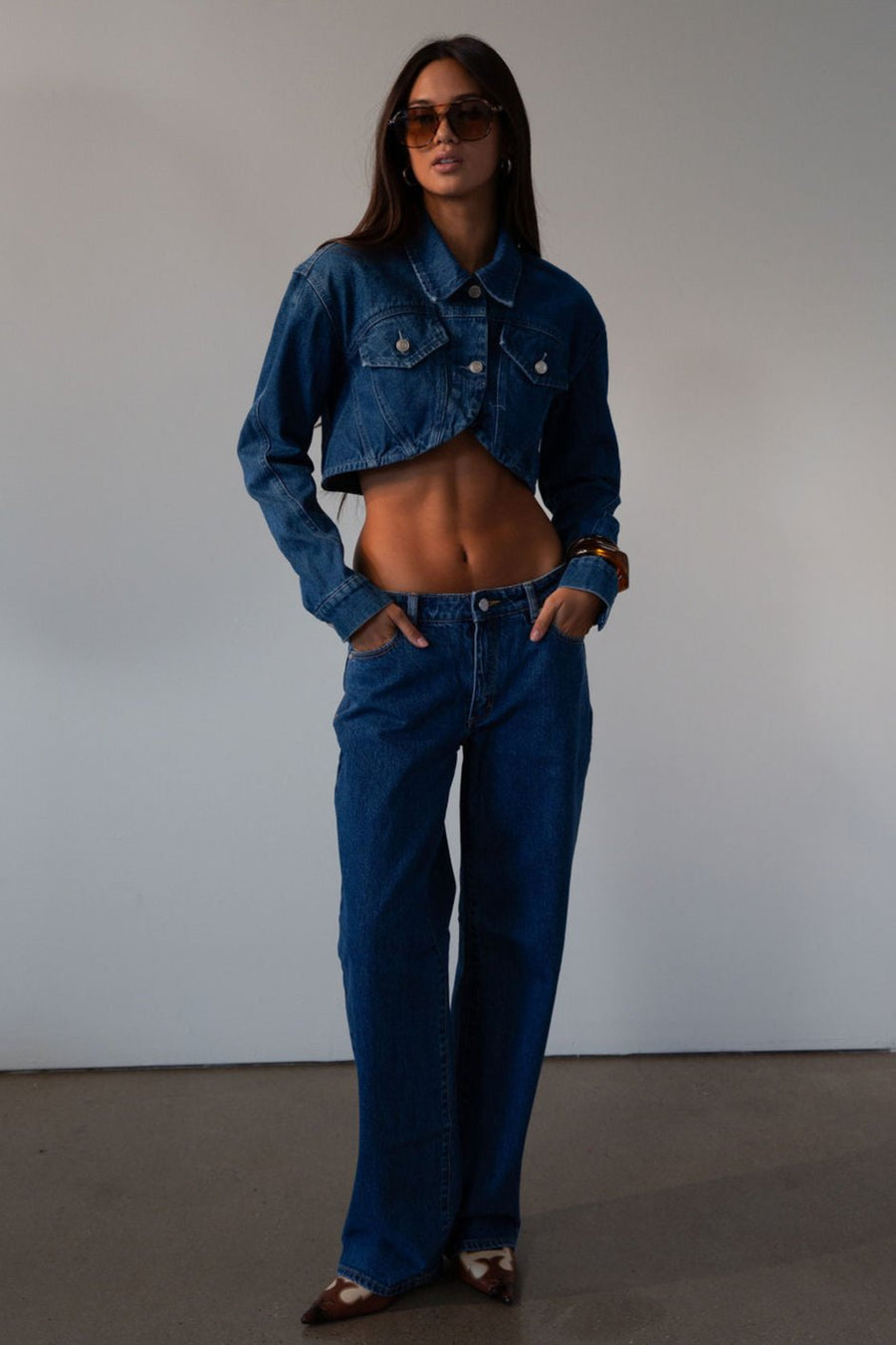 Cropped denim jacket. Collar neckline. Long sleeves with button closures. Front button closures. Unlined.