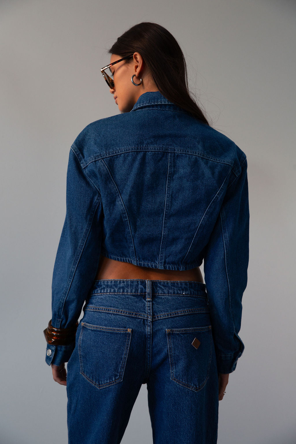Cropped denim jacket. Collar neckline. Long sleeves with button closures. Front button closures. Unlined.