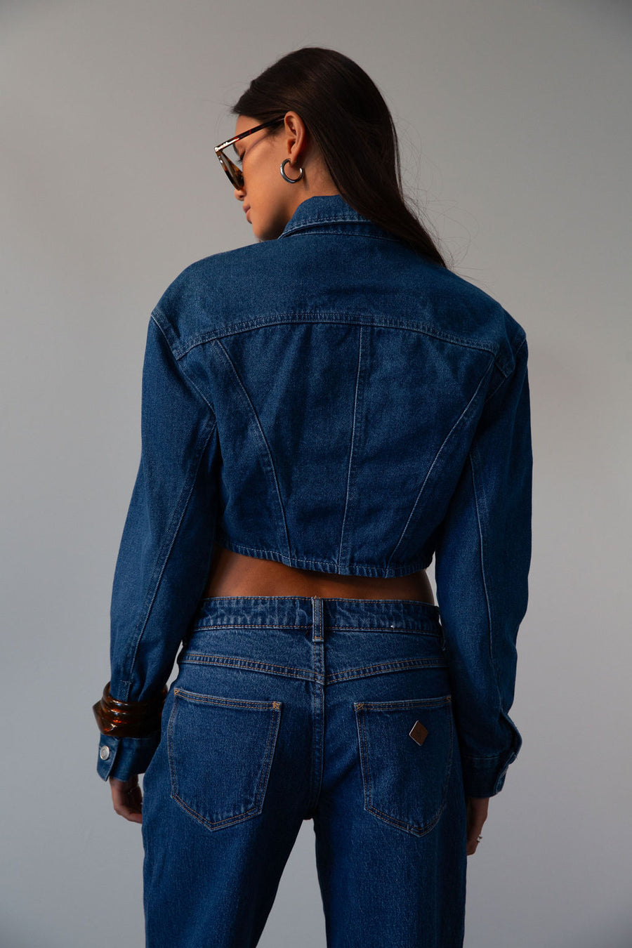 Cropped denim jacket. Collar neckline. Long sleeves with button closures. Front button closures. Unlined.