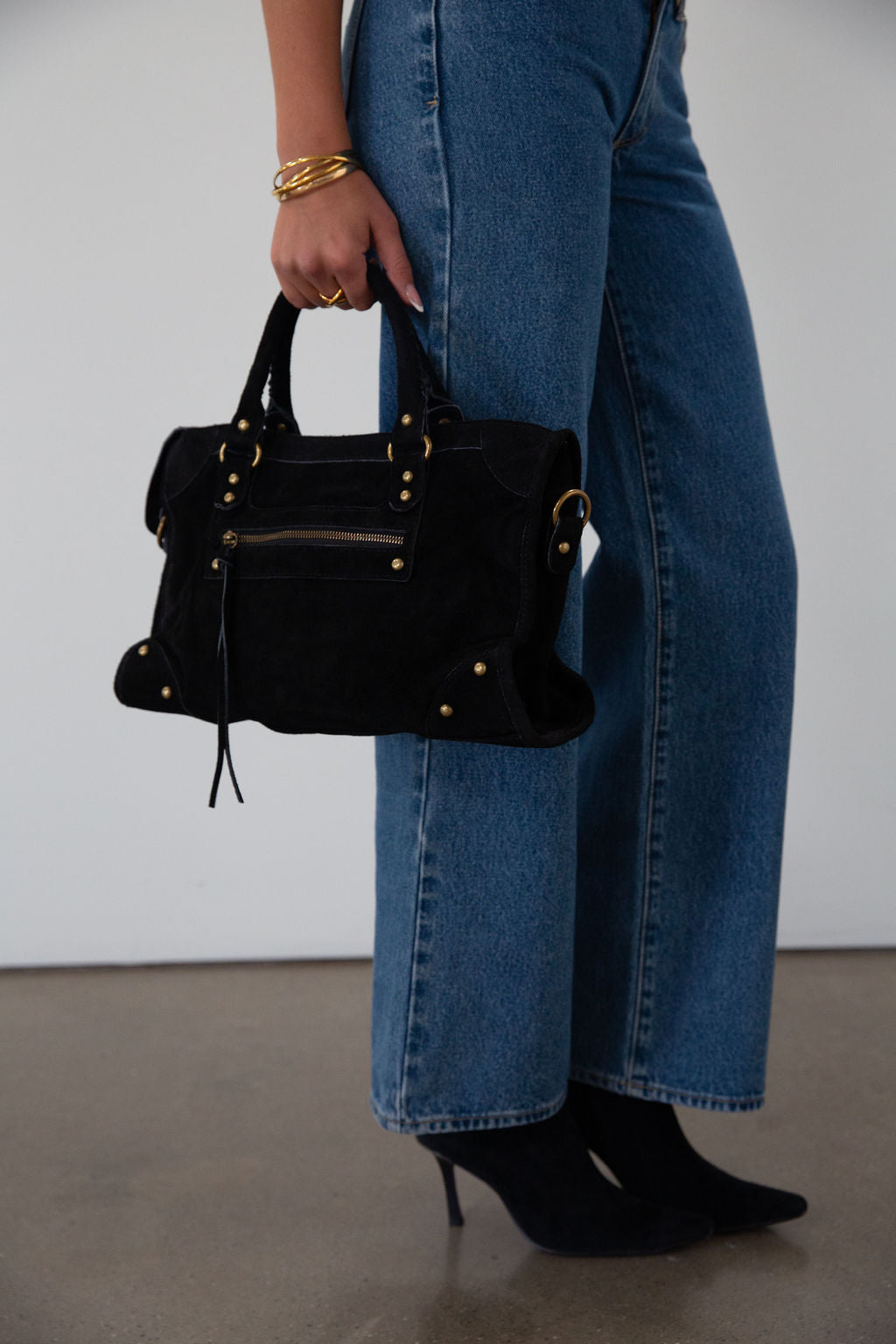 black Suede bag. Adjustable/detachable strap. Fixed top handles. Top zipper closure. Front zipper pocket. Fully lined. Inner pockets and zipper pocket.