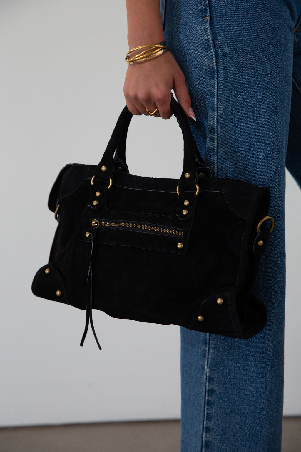 black Suede bag. Adjustable/detachable strap. Fixed top handles. Top zipper closure. Front zipper pocket. Fully lined. Inner pockets and zipper pocket.